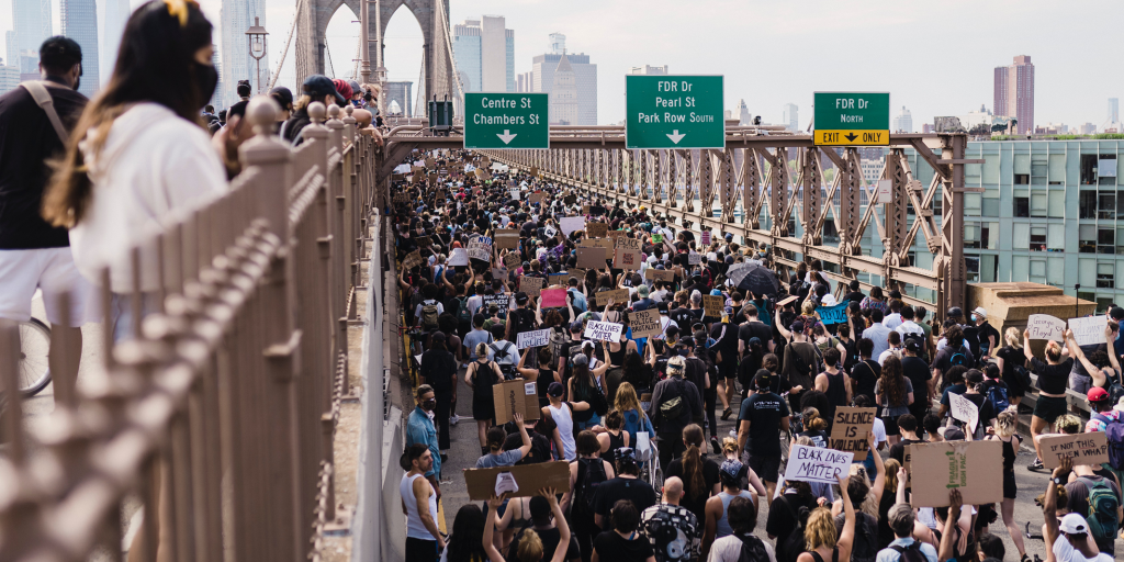 Crowd of people walking across bridge